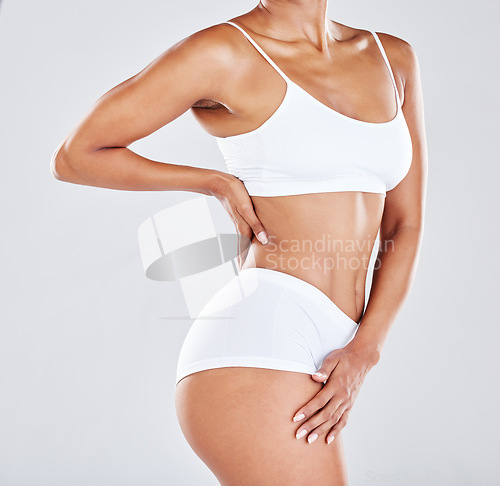 Image of Fitness, wellness and stomach of woman in studio after workout, exercise and training to lose weight. Slim body, skincare and abdomen of female model for nutrition, diet routine and healthy lifestyle