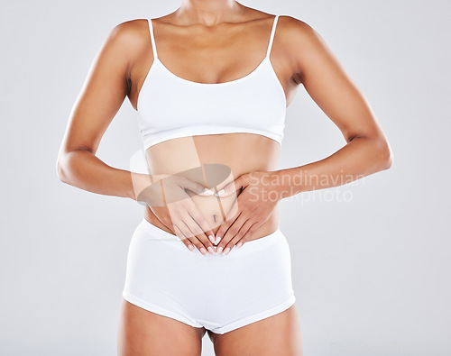 Image of Health, wellness and hands on stomach of woman in studio for nutrition, healthy eating and digestion. Fitness, body care and abdomen of female model for diet, lose weight and liposuction treatment