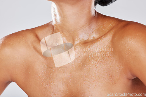 Image of Woman neck sweating due to exercise with wet skin as water drip on a female body isolated in studio white background. Shower, model and active person chest with liquid drops due to sports