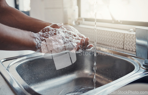 Image of Cleaning, washing hands and kitchen sink with soap for health, home wellness and safety. Cleaner, bacteria prevention and man getting ready for cooking in a household with water doing house chores