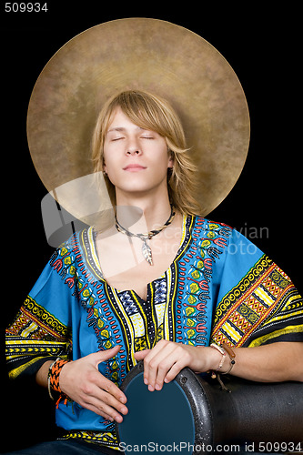Image of The young man plays a drum over black
