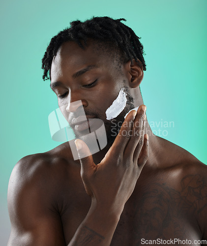 Image of Black man with shaving cream, skincare product on face in studio background and smooth facial hair. Young african model grooming, male hygiene and cleaning beard with cosmetic morning routine