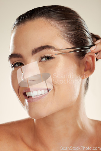 Image of Beauty, face and woman portrait with tweezer for eyebrow cleaning or hair removal in studio. Happy aesthetic model with a smile for facial, cosmetic tools and clean skin for self care routine