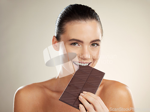 Image of Beauty portrait, eating and woman with chocolate, junk food or dessert for sugar sweets, candy snack or cheat meal. Cosmetics makeup, skincare and hungry model with cacao product for antioxidants