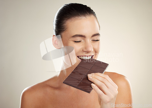 Image of Beauty, eating and face of woman with chocolate bar, junk food or dessert for sugar sweets, candy snack or cheat meal. Cosmetics makeup, skincare and hungry model with cacao product for antioxidants