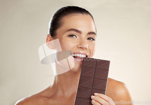 Image of Beauty portrait, eating and woman with chocolate bar, junk food or dessert for sugar sweets, candy snack or cheat meal. Cosmetics makeup, skincare and hungry model with cacao product for antioxidants