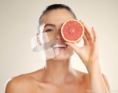 Image of Beauty, skincare and grapefruit for portrait of a woman with natural skin dermatology product. Vitamin c fruit on face aesthetic model in studio for sustainable cosmetics for health and wellness