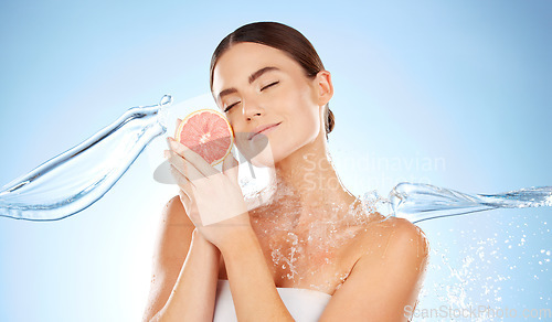 Image of Beauty, skincare and woman with grapefruit and water for natural skin dermatology. Clean splash and face of aesthetic model in studio for sustainable fruit self care for health and spa wellness