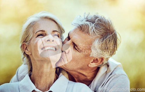 Image of Senior couple, kiss and cheek with smile for love, romance and embrace together in the nature outdoors. Happy elderly woman and man kissing face for romantic bonding or quality time in happiness