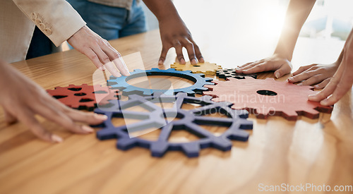 Image of Hands, collaboration and gear with a business team working together in synergy for innovation at a workshop. Meeting, teamwork and creative with a man and woman employee group at work in the office