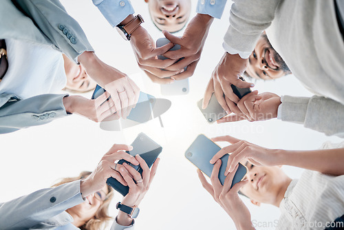 Image of Phone in hands, technology and business people, collaboration and communication in team for company. Chat, internet and community diversity, networking and typing in teamwork circle from below