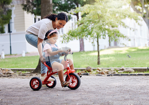 Image of Mother teaching child, bike and learning in park, outdoor with growth and development, family and care. Nature, learn to ride tricycle with woman and girl, childhood and parenting with happy female