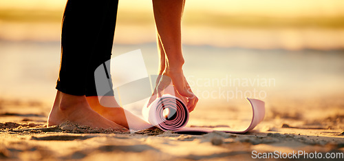 Image of Hands, beach and woman roll yoga mat to start workout, exercise or stretching. Zen, meditation and feet of female yogi outdoors on seashore while preparing for chakra training, exercising and pilates