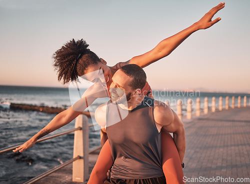 Image of Beach, fitness and couple piggyback at sunset happy for summer holiday, vacation and quality time on weekend. Love, dating and black man and woman relax after exercise, workout and training by ocean