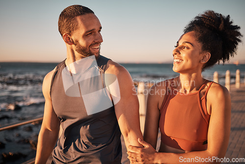 Image of Black couple, fitness and walking at the beach with smile for conversation, talk or sunset together in the outdoors. Happy man and woman enjoying fun walk smiling for holiday break by the ocean coast
