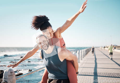 Image of Beach, fitness and couple piggyback in summer enjoying holiday, vacation and quality time on weekend. Love, dating and black man and woman relax after running, exercise workout and training by ocean