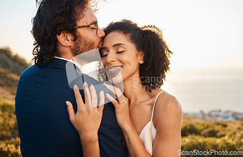 Image of Love, kiss and wedding with couple in nature for celebration, happiness and romance. Sunset, hug and affectionate with bride and groom in embrace at countryside for happy, marriage and smile together