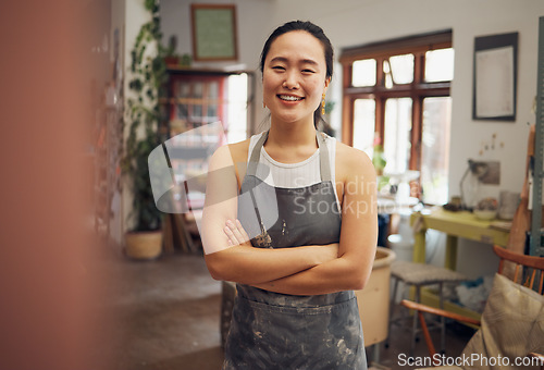 Image of Asian woman, potter or arms crossed portrait in pottery studio, small business or ceramic workshop. Smile, happy or clay product worker and confidence, vision ideas or goals for creative store design