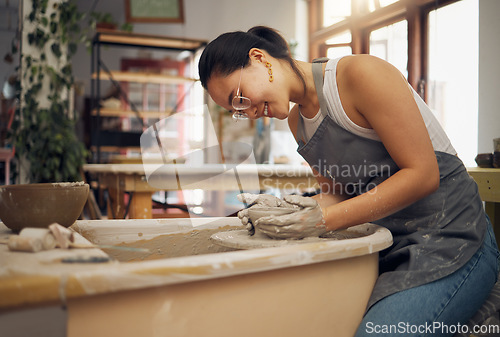 Image of Pottery wheel, workshop and startup business woman manufacturing creative art product with hands. Happy asian potter artist working in clay or ceramics retail industry, studio or class with pride