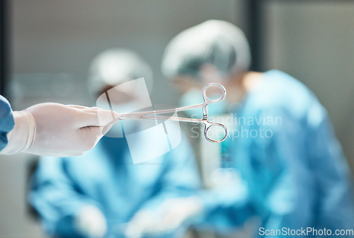 Image of Hospital scissors, surgery and team of doctors in theatre for medical trust, innovation or support with healthcare insurance background. Hand holding tools, surgeon or nurse helping in operating room