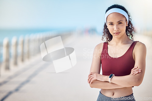 Image of Fitness, portrait and woman with arms crossed at beach promenade for exercise, wellness and mockup in Miami. Female sports athlete standing at seaside outdoor for workout, summer training and running