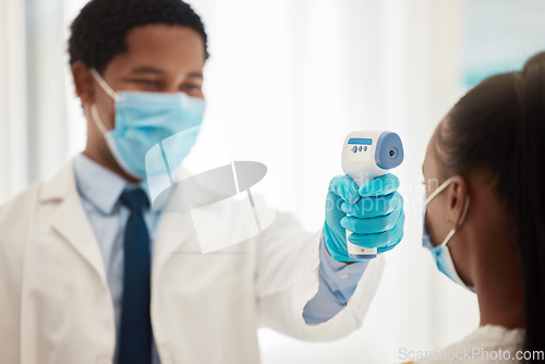 Image of Doctor, patient or thermometer in covid check, hospital compliance or healthcare wellness control in clinic. Black woman, face mask or forehead fever temperature for virus management or medical help