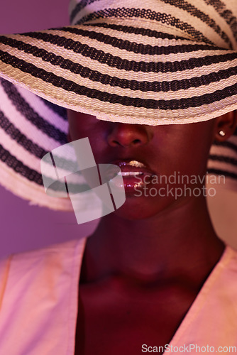 Image of Fashion, model and black woman in neon light, UV and purple studio background wearing a sun hat. Style, makeup and beauty by female with dark skin aesthetic creativity and color design