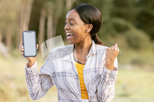 Image of Black woman, phone and mockup display for winning, discount or sale with smile in nature. Happy African American female smiling for giveaway prize, deal or achievement on smartphone in the outdoors