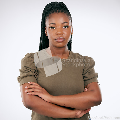 Image of Black woman, arms crossed and standing isolated on gray background for confident profile or empowerment. Portrait of African American female model with serious face for leadership or management