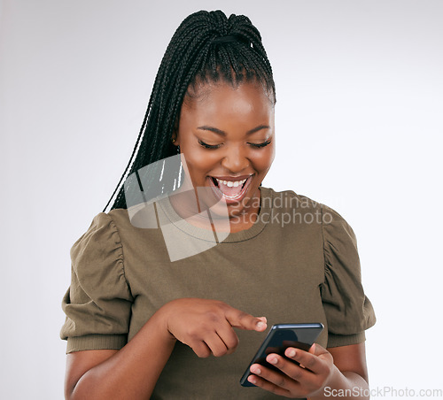 Image of Phone, funny and woman laughing in a studio while watching a video on social media or the internet. Happy, smile and African female looking at a meme on her cellphone isolated by a white background.