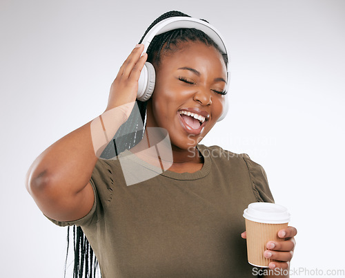 Image of Headphones, black woman and music listening with coffee of a happy young person in a studio. White background, isolated and happiness of a excited female hearing audio and singing to song alone