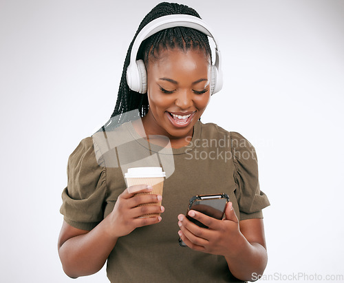 Image of Phone, music and coffee with a black woman in studio on a gray background listening to the radio. Mobile, social media or headphones and a young female streaming an audio playlist with a drink