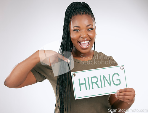 Image of Creative business woman, pointing and hiring sign for recruiting isolated on gray studio background. Portrait of happy African American female manager with board for recruitment, job hire or startup