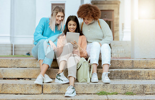 Image of Student, friends and tablet on stairs in social media, communication or streaming entertainment at campus. Happy women enjoying online research, chat or browsing on touchscreen together on staircase