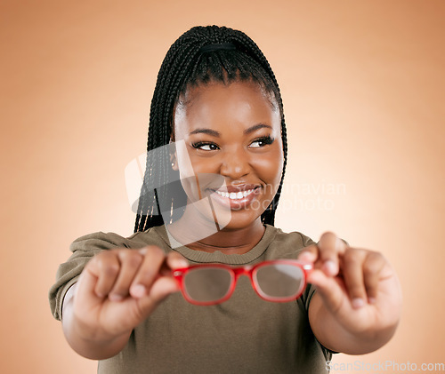 Image of Glasses, black woman and frame choice of a happy young person hands holding frames in a studio. Brown background, isolated and happiness of a female thinking about lens vision and eye healthcare