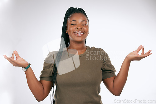 Image of Meditation, black woman and peace in studio, smile and gratitude of trust. Happy female, zen hands and meditate on background for mindset, chakra energy and relax with yoga, wellness and healthy soul