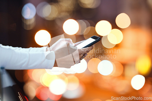 Image of Closeup, hands and person texting in a city at night, blank and screen with mockup against bokeh background. Zoom, fingers and hand with smartphone and copy space for text, chat or online search