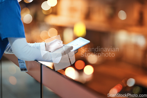 Image of Tablet, hands and nurse at hospital rooftop working on telehealth, research or online consultation in city. Bokeh, healthcare and woman with touchscreen technology for wellness app in clinic at night