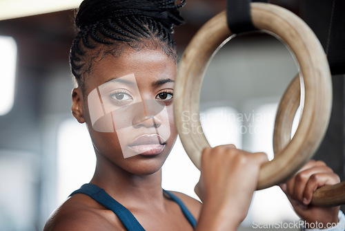 Image of Fitness, gymnastics and portrait of a black woman with rings for training, muscle and arms at gym. Focus, strong and face of an African gymnast with performance during a workout or exercise at a club