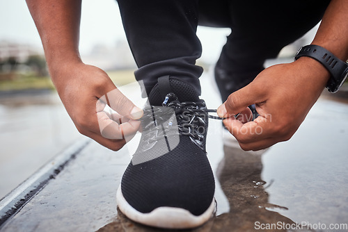 Image of Exercise, shoes and running with a sports man tying his laces for an outdoor cardio or endurance workout. Fitness, footwear and training with a male athlete or runner fastening his shoelaces outside