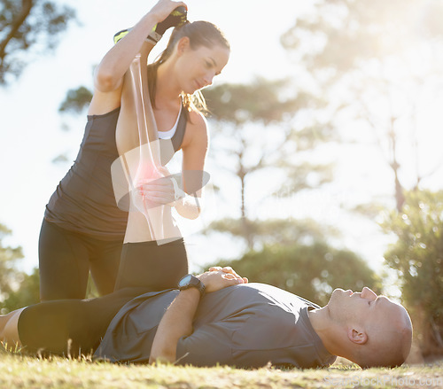 Image of Fitness, couple and helping or stretching leg for healthcare, pain or ache after running workout in nature. Happy woman holding man legs for stretch to sooth painful knee or area from cardio exercise