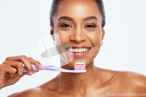 Image of Portrait, cleaning and a black woman brushing teeth in studio isolated on a white background for oral hygiene. Face, toothbrush or toothpaste with a young female posing for dental care on blank space