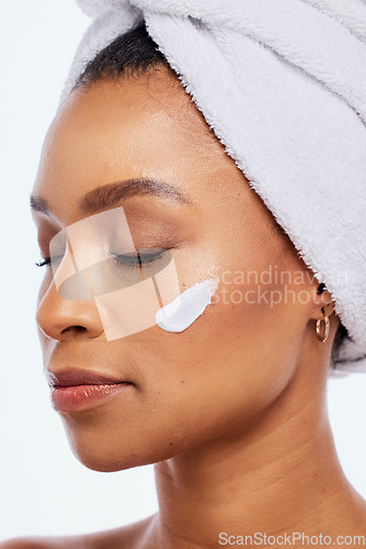 Image of Black woman, skin care and beauty cream in studio for dermatology, cosmetics and natural glow. Aesthetic model person with luxury spa facial and healthy face with towel isolated on a white background