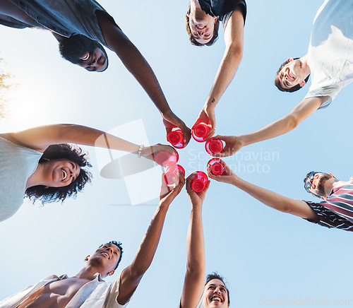 Image of Cheers, sky and alcohol with a group of friends making a toast together at a party from below. Beer, freedom and drink with a man and woman friend group toasting outdoor during summer celebration