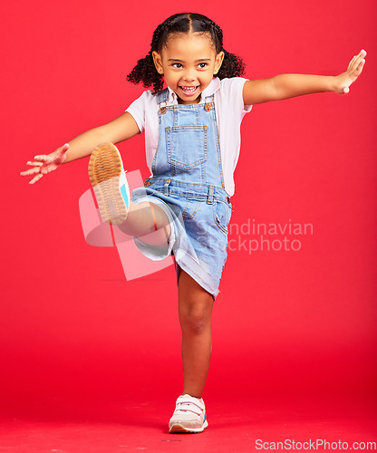 Image of Happy, youth and girl on red background kick legs for happy childhood, positive mindset and smile. Fashion mockup, summer style and cute face of child in studio with freedom, carefree and happiness