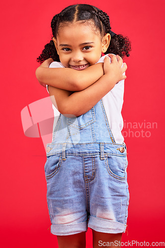 Image of Portrait, hug and girl in studio, happy and smile against red background with mockup. Face, love and caring toddler standing against space, embrace and positive, smiling and self love while isolated