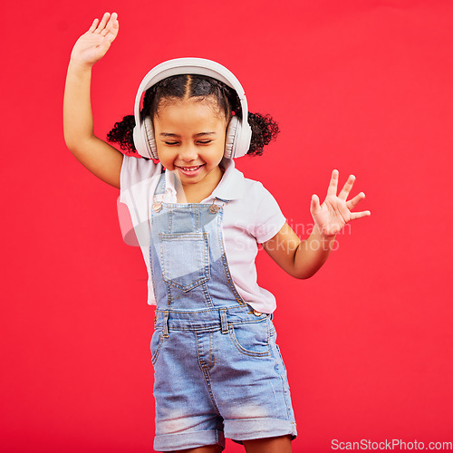 Image of Dance, energy and happy child on music headphones, fun radio and dancing podcast on isolated red background. Smile, girl and dancer kid listening to audio, streaming sound and media on studio mockup