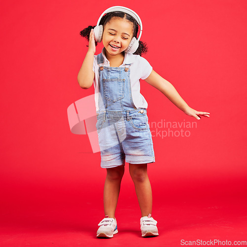 Image of Dancing, energy or little girl on music headphones, fun radio or childrem podcast on isolated red background. Smile, happy or dancer kid listening to audio, sound and streaming media on studio mockup