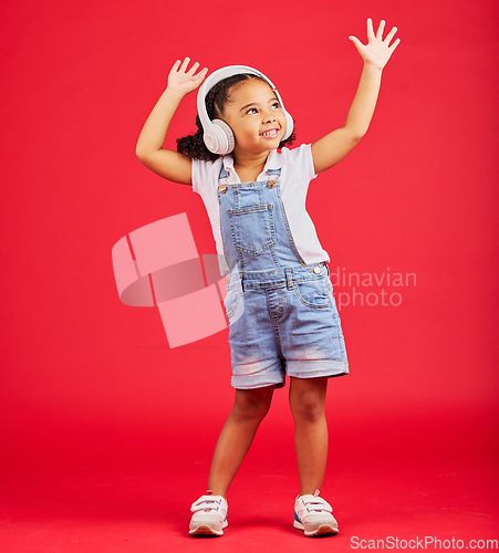 Image of Dance, energy or happy kid on music headphones, fun radio or dancing podcast with hands up on red background. Smile, girl or dancer child listening to audio, streaming sound or media on studio mockup