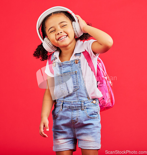 Image of Student, child or headphones for music, school podcast or education radio in nursery song, sound or learning audio. Smile, happy or kid listening to fun studying media with backpack on red background